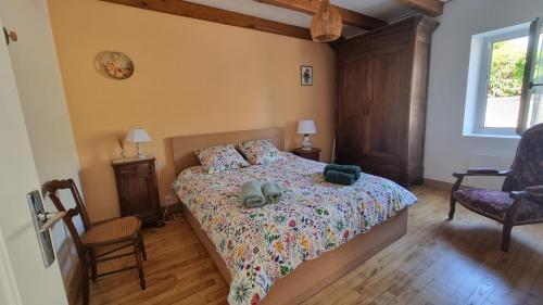a bedroom with a bed and two chairs and a window at Maison de Pierre in Septfonds