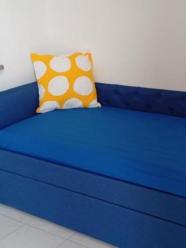 a blue couch with a yellow pillow on it at Costadeiapartments in Briatico