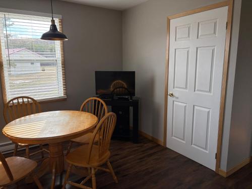 a dining room with a table and chairs and a door at The Sunshine Inn in Parrsboro