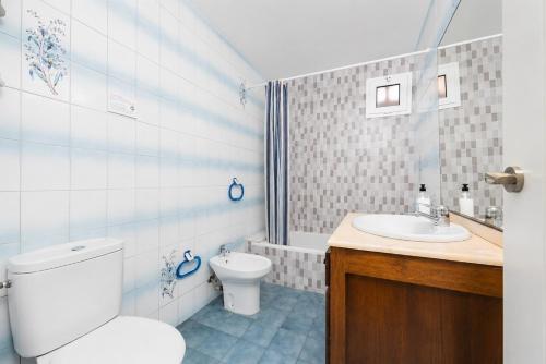a bathroom with a toilet and a sink at Villa Mares in Cala en Porter