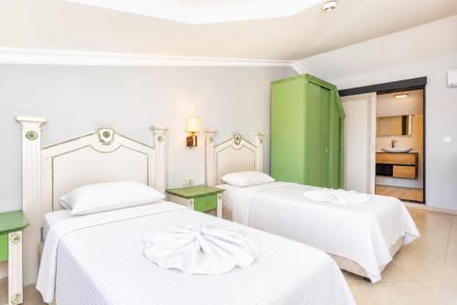 a bedroom with two beds and a green cabinet at Villa Deniz Paradise in Dalyan
