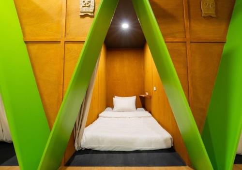 a bed in a small room with green walls at 3BU Hostel Baguio - Bonifacio in Baguio
