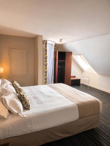 a bedroom with a large bed in a room at Kyriad Saint-Malo Dinard in La Richardais