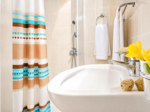 a bathroom with a sink and a shower curtain at Villa Antigoni in Alikias