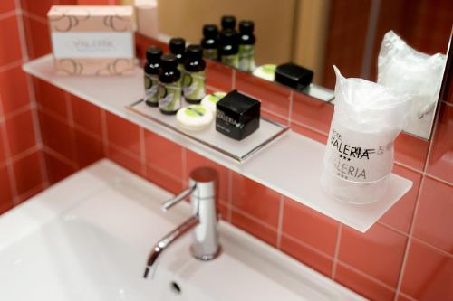 a bathroom counter with a sink and a mirror at Hotel Valeria in Villa Opicina