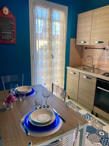 a kitchen with a table with plates and wine glasses at La casetta di Andreina in Sarzana