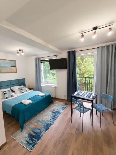 a bedroom with a bed and a table and chairs at Apartamenty Bliza in Ostrowo