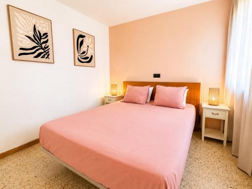 a bedroom with a pink bed with two pink pillows at Les cases del vent I in L'Ametlla de Mar