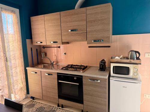 a kitchen with wooden cabinets and a stove top oven at La casetta di Andreina in Sarzana