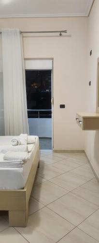 a white room with a bed and a window at Βeachfront Luxury Apartments SARANDE in Sarandë