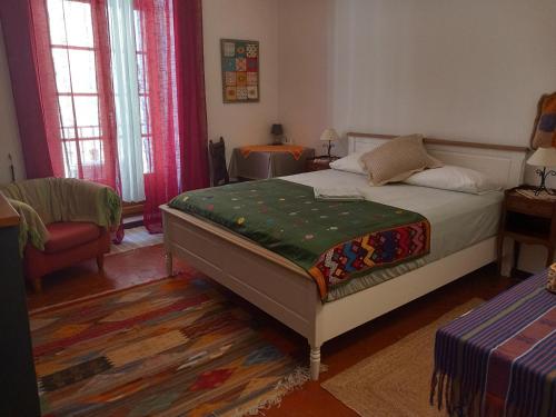 a bedroom with a bed and a chair and windows at La Petite Maison de Caractere Catalan in Argelès-sur-Mer