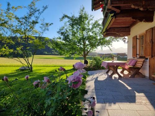 a patio with a bench and flowers in a yard at Chalet Menkenhof in Reit im Winkl
