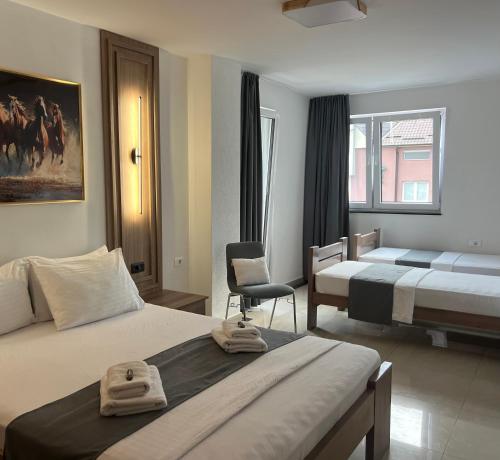 a hotel room with two beds and a chair at Hotel Palace Struga in Struga