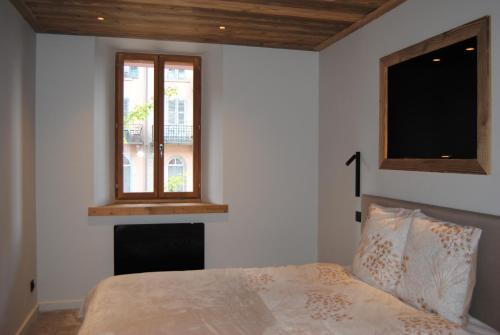 a bedroom with a bed with a fireplace and two windows at Mont Joly 2 in Le Baplieu