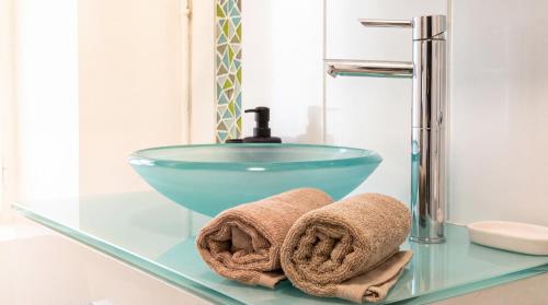 a bathroom with a glass bowl sink and towels at Cozy & Stylish, hyper center in Quimper