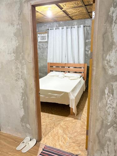 a small bedroom with a bed and a mirror at Uya Mina Homestay in General Luna