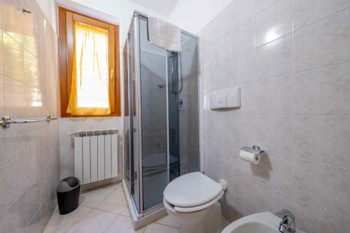 a bathroom with a toilet and a glass shower at Happy Guest Apartments - Lake Panorama & Pool in Riva di Solto