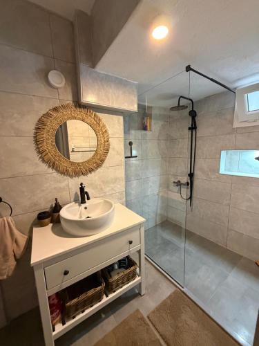 a bathroom with a sink and a shower with a mirror at Villa Deja Blue in Karaburun