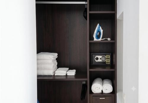 a closet with a shelf with towels and a camera at ICON Oceanview Retreat by Monyxbnb in Puerto Vallarta