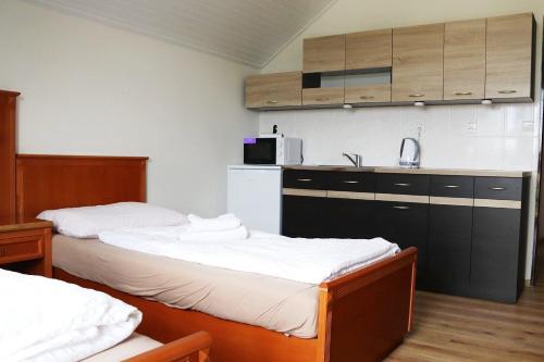 two beds in a small room with a kitchen at B&B Hotel Volčík in Mariánské Lázně