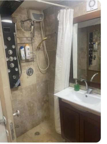 a bathroom with a sink and a shower with a shower curtain at OSHER Simple house in Nahariyya