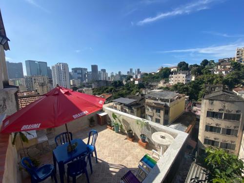 a patio with a red umbrella and chairs on a building at Carioca Lapa Hostel in Rio de Janeiro