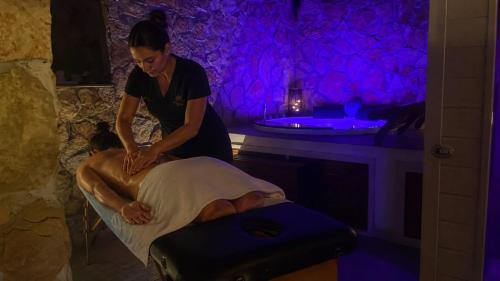 a woman bathing a man in a bed with a suitcase at SPA SUITE SICILIA - Suite con Spa privata ad uso esclusivo Jacuzzi Sauna Hammam in Rosolini