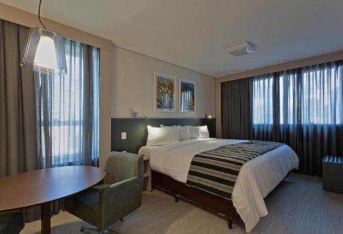 a hotel room with a bed and a table and a chair at Living Sion in Belo Horizonte