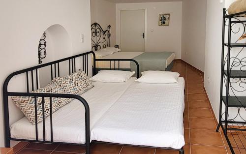 zwei Betten in einem Zimmer mit weißer Bettwäsche in der Unterkunft Casa Yalbash in Elvas