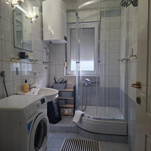 a bathroom with a shower and a washing machine at Top Topla - Herceg Novi in Topla