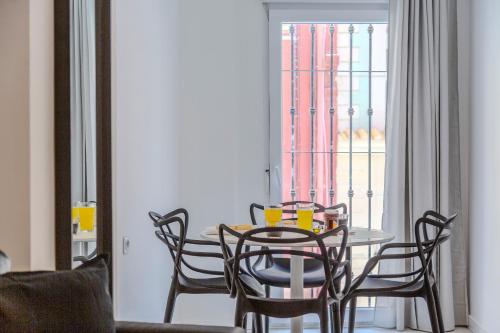 a dining room with a table and chairs and a window at Trendy Homes Almeria Center in Almería
