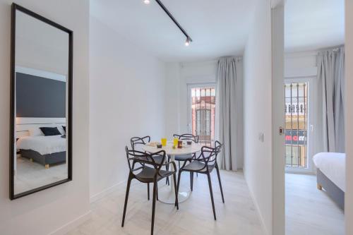 a dining room with a table and chairs and a mirror at Trendy Homes Almeria Center in Almería
