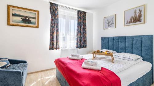 a small bedroom with a bed with a red blanket at Osiedle Bursztynowe in Jantar