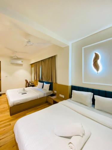 a hotel room with two beds and a painting on the wall at Hotel Sun City in Kalol