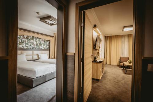 a hotel room with a bed and a room with a mirror at Hotel ZOO Sofia in Sofia