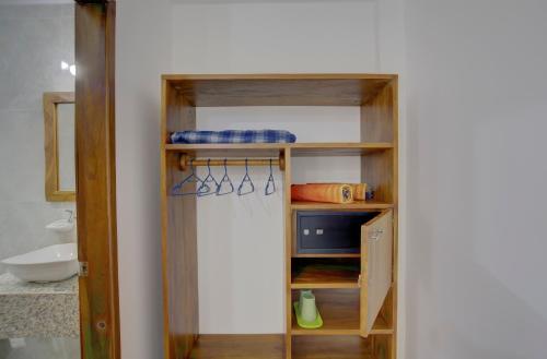 a bathroom with a closet with a sink and a shelf at Hotel Red Booby in Puerto Ayora