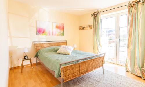 a bedroom with a bed and a large window at Schleimündeblick in Olpenitz