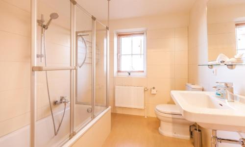 a bathroom with a shower and a toilet and a sink at Schleimündeblick in Olpenitz