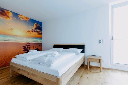 a bedroom with a bed with a painting on the wall at Beach SUN and FUN Penthouse in Podersdorf am See