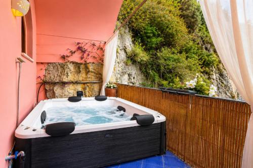 a jacuzzi tub sitting on the side of a house at Luxury Maison Cherie - Positano Charme & Sea View in Positano