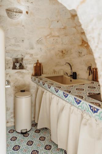 a bathroom with a sink and a bath tub at Siede la Terra - Trullo con piscina in Ceglie Messapica