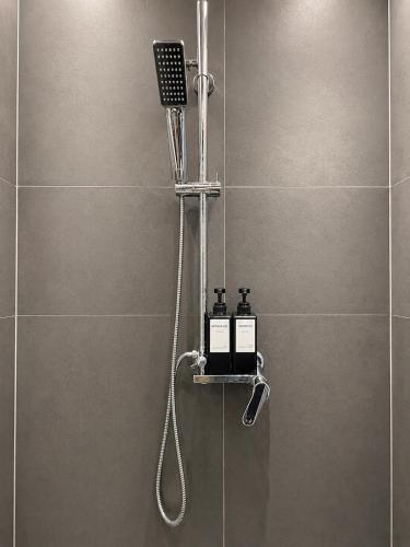 a bathroom with a shower with two soap bottles at Appartamento Martina in Lanusei
