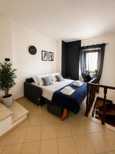 a bedroom with a large bed with a blue blanket at Appartamento Martina in Lanusei