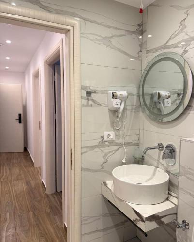 a bathroom with a sink and a mirror at Galaxy Hotel in Ksamil