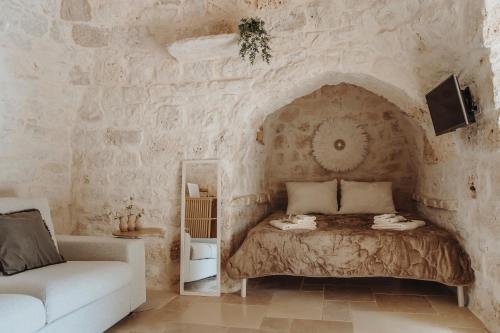 a bedroom with a bed in a stone wall at Siede la Terra - Trullo con piscina in Ceglie Messapica