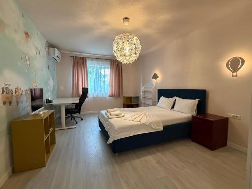 a bedroom with a bed and a desk and a computer at Elegant Garden Villa American Village Pipera in Voluntari