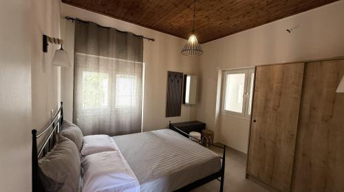 a bedroom with a bed and a window at Ria's Garden House in Kassiopi