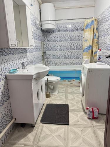 a bathroom with a sink and a toilet and a tub at Hostel Hanysha in Kazarman