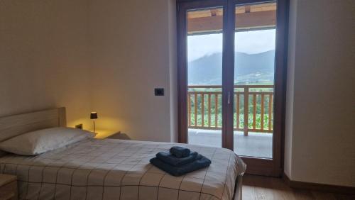 a bedroom with a bed and a balcony with a view at MASO CLENA in Balbido-rango