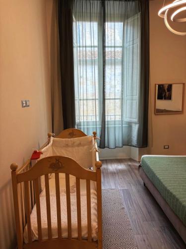 a baby room with a crib and a window at Appartamento in centro storico. in Camaiore
